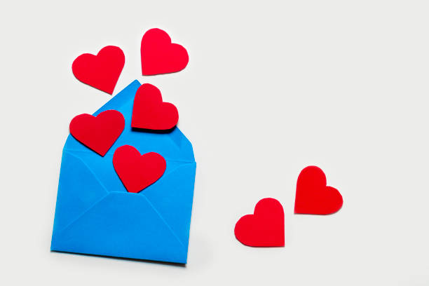 istock Five red hearts fly out of a blue paper envelope. And two lie side by side on a light background. The concept of celebration, love and relationships. With place for text. 1319454864