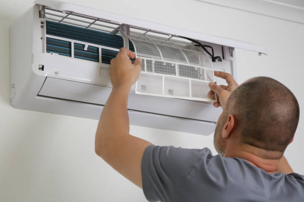 istock Man putting new clean air filter on air conditioner. 1319458094