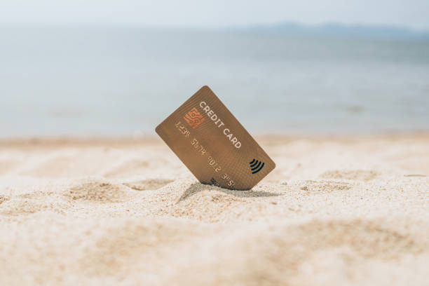 istock Credit card in the sand on the beach 1319458291