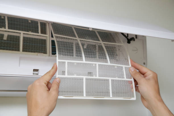 istock Man putting new clean air filter on air conditioner. 1319458699