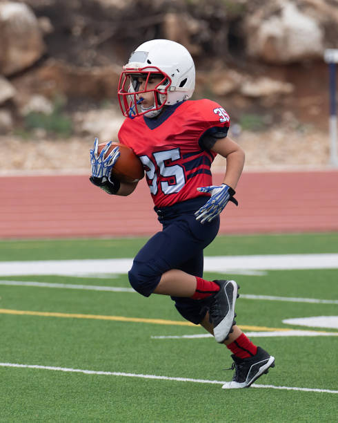 istock Athletic Young Boy Playing in a Football Game 1319459940