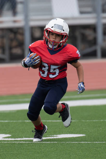 istock Athletic Young Boy Playing in a Football Game 1319459945