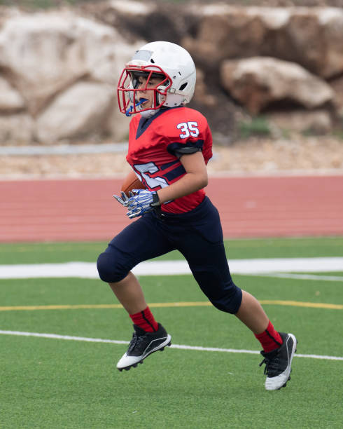 istock Athletic Young Boy Playing in a Football Game 1319459946