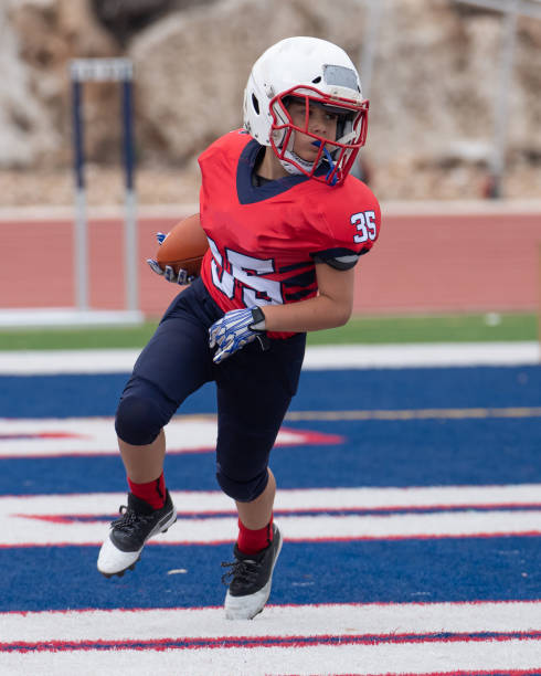istock Athletic Young Boy Playing in a Football Game 1319459952