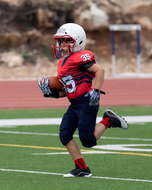 istock Athletic Young Boy Playing in a Football Game 1319459954