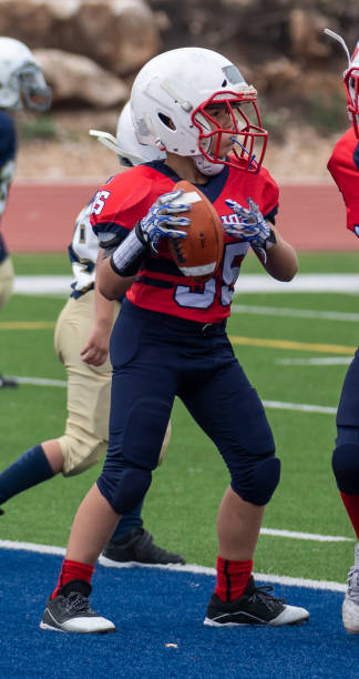 istock Athletic Young Boy Playing in a Football Game 1319459956