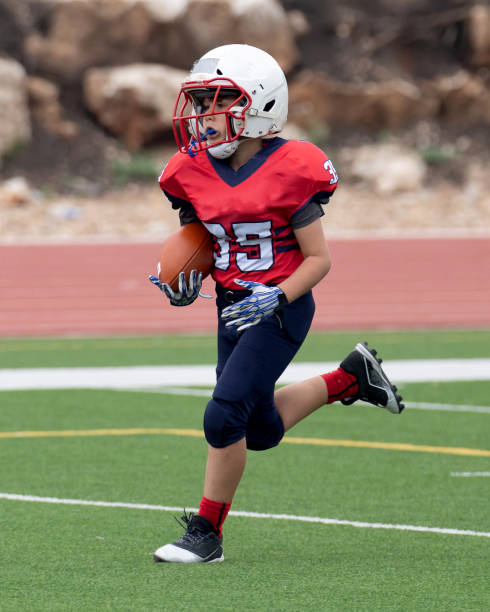 istock Athletic Young Boy Playing in a Football Game 1319459958