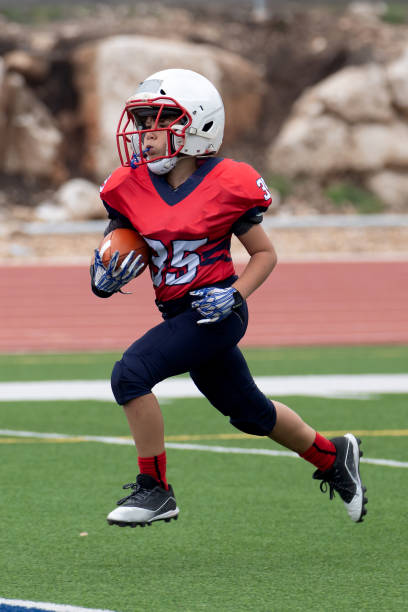 istock Athletic Young Boy Playing in a Football Game 1319459960