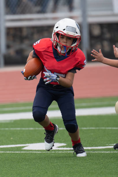 istock Athletic Young Boy Playing in a Football Game 1319459977