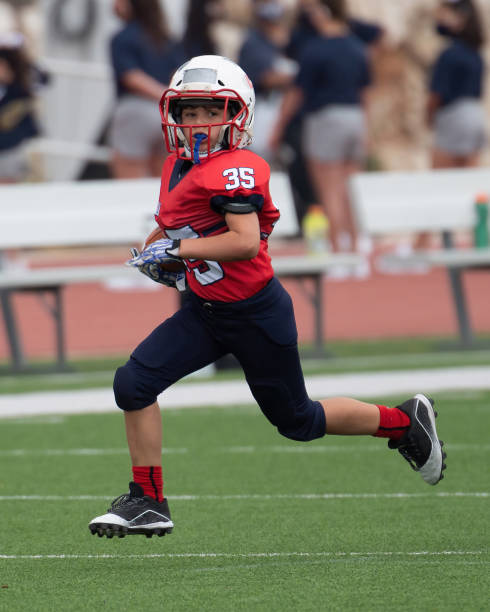 istock Athletic Young Boy Playing in a Football Game 1319459980