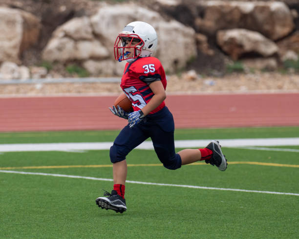 istock Athletic Young Boy Playing in a Football Game 1319459986