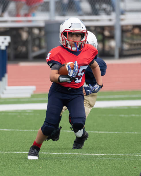 istock Athletic Young Boy Playing in a Football Game 1319459997