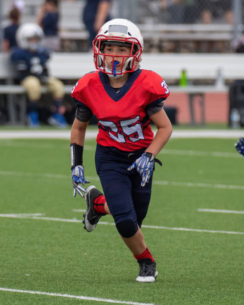 istock Athletic Young Boy Playing in a Football Game 1319459999