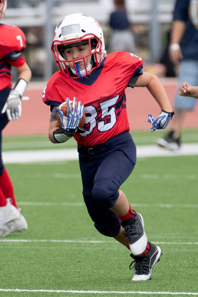 istock Athletic Young Boy Playing in a Football Game 1319460003