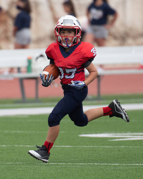 istock Athletic Young Boy Playing in a Football Game 1319460007