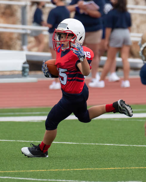 istock Athletic Young Boy Playing in a Football Game 1319460013