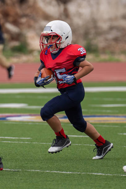 istock Athletic Young Boy Playing in a Football Game 1319460015