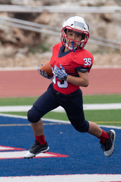 istock Athletic Young Boy Playing in a Football Game 1319460155