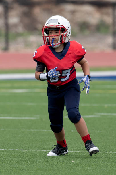 istock Athletic Young Boy Playing in a Football Game 1319460156