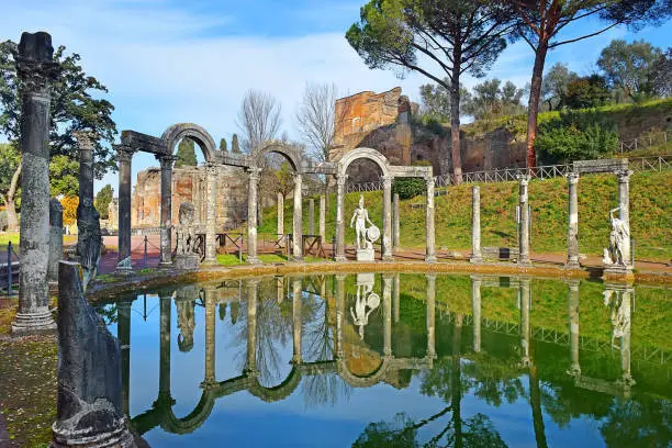 ancient pool called Canopus, surrounded by greek sculptures in Villa Adrian (Hadrian's Villa) and reflections in water in Tivoli, Italy
