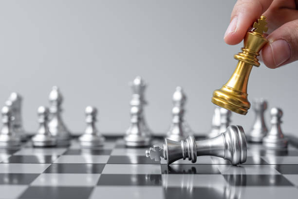 istock businessman hand moving gold Chess King figure and Checkmate opponent during chessboard competition. Strategy, Success, management, business planning, disruption and leadership concept 1319462073