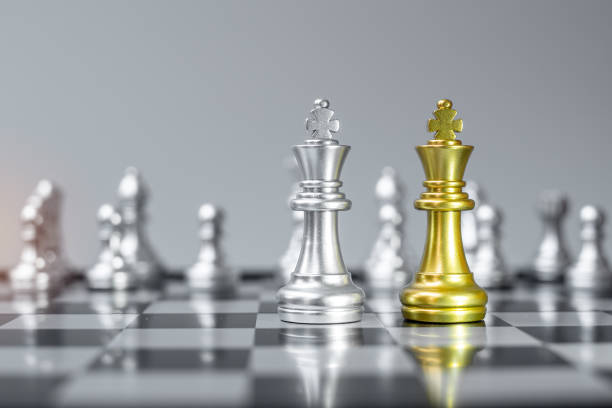 istock Gold and silver Chess King figure on Chessboard against opponent or enemy. Strategy, Conflict, management, business planning, tactic, politic, communication and leader concept 1319462522