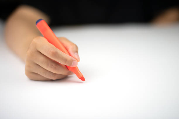 istock Cropped hand holding orange marker on white paper 1319462935