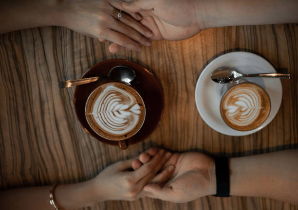 istock Couple holding hands in coffee date with latte art 1319463695