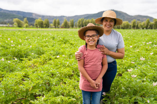 felice madre e figlia latinoamericana che lavorano sull'agricoltura in una fattoria - agricoltrice foto e immagini stock