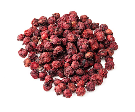 pile of dried magnolia berries (Schisandra Chinensis seeds) closeup on white background