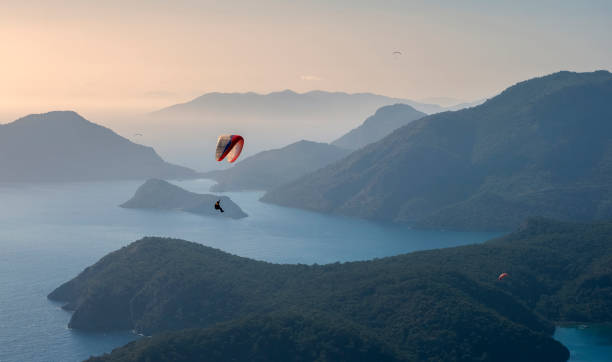 Paragliding over the Blue Lagoon Oludeniz over the sea and mountains in turkey Paragliding over the Blue Lagoon Oludeniz over the sea and mountains in turkey paragliding stock pictures, royalty-free photos & images