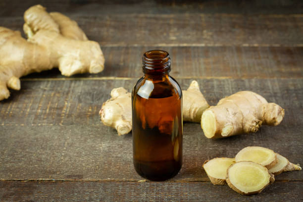 istock Ginger essential oil in bottle and fresh ginger on rustic wooden background. 1319466397