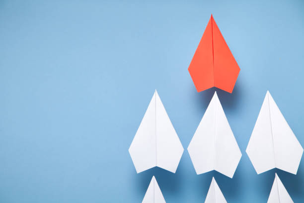 istock Red and white paper airplanes on blue background. Leadership. Teamwork 1319467801