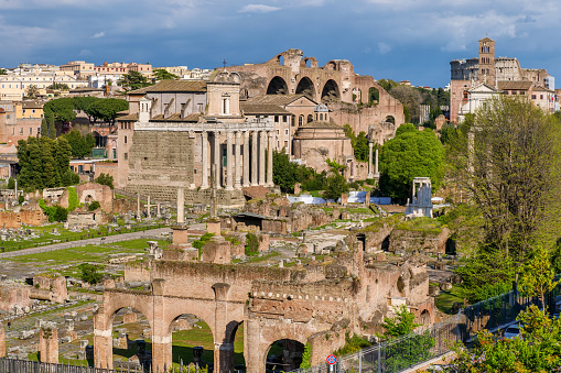A suggestive and detailed view of the Imperial Forums, an area known as the Archaeological Park of the Roman Forum, taken from the Capitoline Hill. The Roman Forum is one of the largest archaeological areas in the world. In the foreground the colonnade of the Temple of Antoninus and Faustina, on its right the circular Temple of Romulus and above the majestic arches of the Basilica of Maxentius. Image in high definition format.