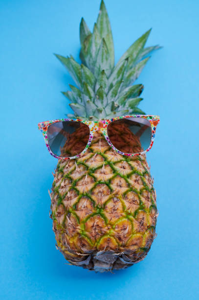 istock pineapple with sunglasses against blue background 1319474098