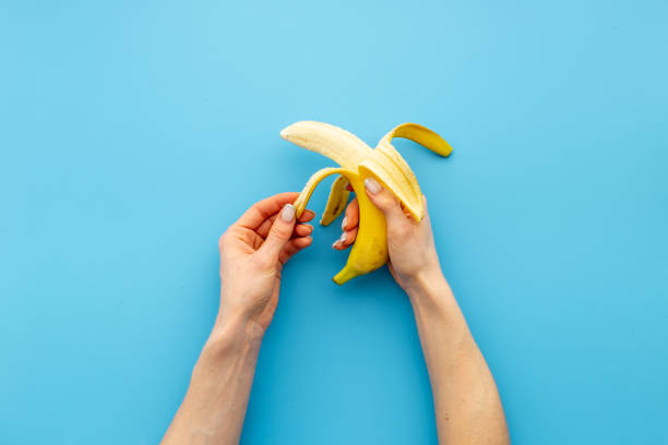 istock Hand holding peeled banana. Top view 1319478497