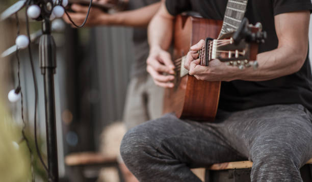 die musiker überprüfen den klang der gitarre und versuchen, gitarre zu spielen, bevor die veranstaltung beginnt. konzert,mini-konzert und musikfestivals. - performer stock-fotos und bilder