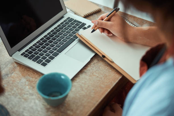istock Female potter writing on notebook and using laptop in workshop 1319479725