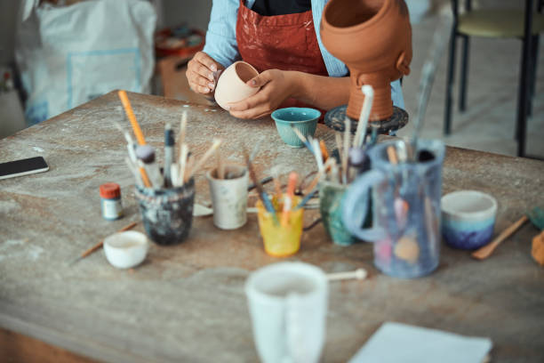istock Female potter hands sanding ceramic pot in pottery workshop 1319479746