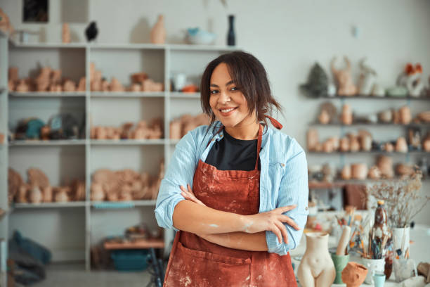 istock Cheerful female ceramist standing in pottery workshop 1319479751