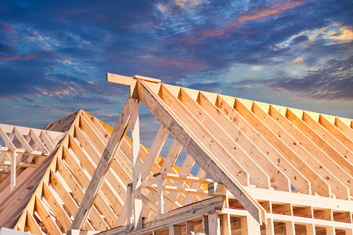 The wooded frame of a new residential house construction at sunset.