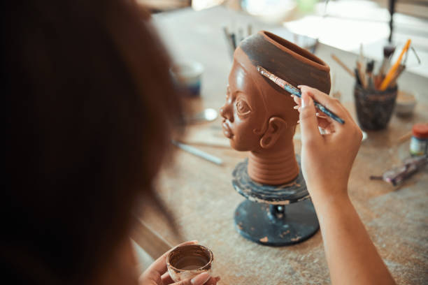 istock Female ceramist hand painting pottery in workshop 1319481605