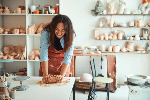 istock Cheerful young woman working in pottery workshop 1319481628