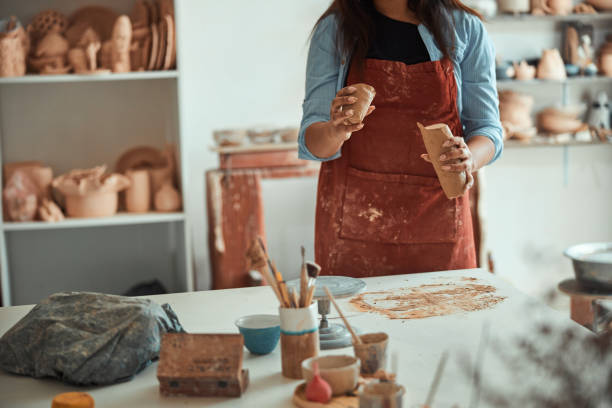 istock Female ceramist in apron working in pottery studio 1319481633