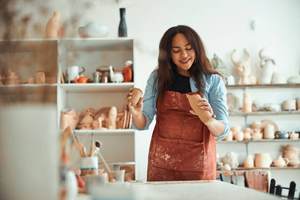 istock Beautiful joyful woman working in pottery workshop 1319481635