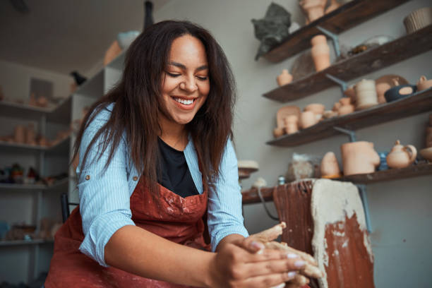 istock Cheerful woman ceramist making pottery in workshop 1319481662