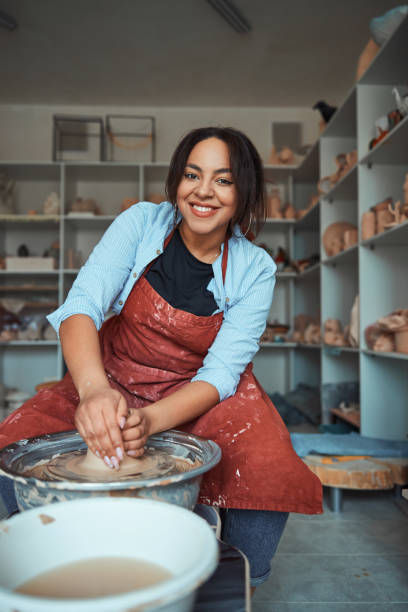 istock Cheerful female ceramist making pottery in workshop 1319481666