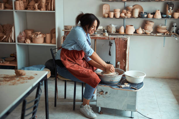 istock Beautiful young woman making pottery in workshop 1319481669