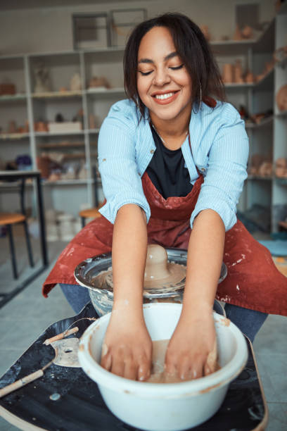 istock Cheerful female potter washing hands after making pottery 1319481676