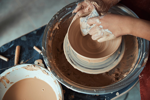 Female potter hands polishing pottery in workshop